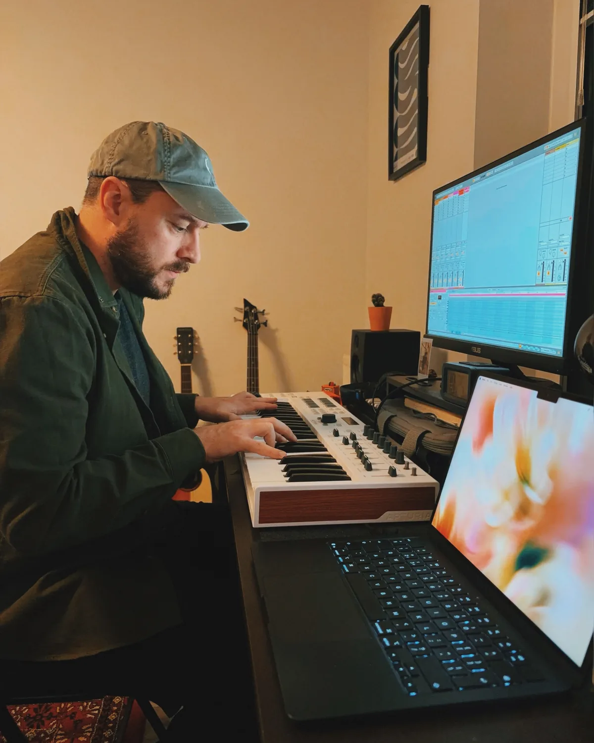 Luke Tyler playing a keyboard in his studio, with Ableton open on the monitor